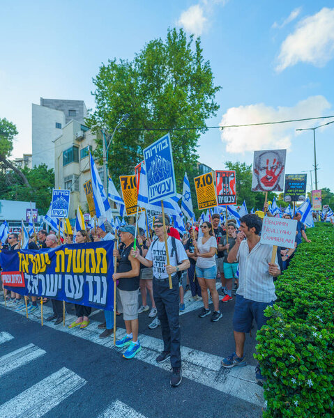 Haifa, Israel - July 06, 2024: Scene of a protest march, against the government, calling for new elections, with people taking part, various signs and flags. Haifa, Israel