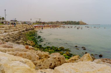 Tel Aviv, İsrail - 10 Mayıs 2024: Sıcak bir bahar gününde, arka planda ziyaretçiler ve eski Jaffa, Tel-Aviv, İsrail