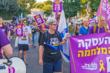 Hayfa, İsrail - 13 Temmuz 2024: İnsanlar hükümete karşı çeşitli tabelalar ve bayraklarla birlikte yeni seçimler çağrısında bulunan bir protesto yürüyüşüne katılıyor. Hayfa, İsrail