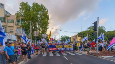Hayfa, İsrail - 13 Temmuz 2024: Hükümete karşı bir protesto yürüyüşü sahnesi, insanların katıldığı, çeşitli tabelalar ve bayraklarla yeni seçimler çağrısında bulundu. Hayfa, İsrail