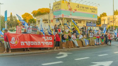 Hayfa, İsrail - 17 Temmuz 2024: Çeşitli tabelaları ve bayrakları olan insanlar, ABD 'ye gitmeden önce rehine anlaşması çağrısında bulunarak hükümete karşı düzenlenen bir protestoya katıldılar. Hayfa, İsrail