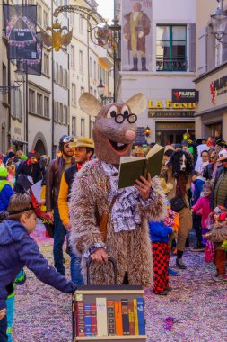 Lucerne, İsviçre - 21 Şubat 2023: Kostüm giymiş bir grup katılımcı ve kalabalık, İsviçre 'nin Lucerne kentinde düzenlenen Fasnacht Karnavalı' nın çocuk geçit töreninin bir parçası.
