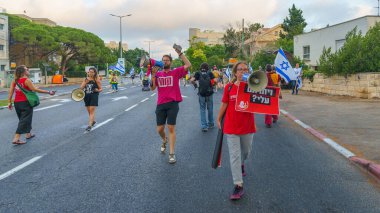 Hayfa, İsrail - 20 Temmuz 2024: Bir protesto yürüyüşü sahnesi, hükümete karşı, insanların katıldığı, çeşitli tabelalar ve bayraklarla yeni seçimler çağrısında bulundu. Hayfa, İsrail