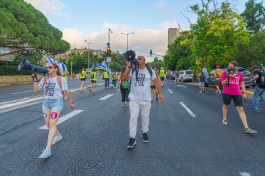 Hayfa, İsrail - 20 Temmuz 2024: Bir protesto yürüyüşü sahnesi, hükümete karşı, insanların katıldığı, çeşitli tabelalar ve bayraklarla yeni seçimler çağrısında bulundu. Hayfa, İsrail