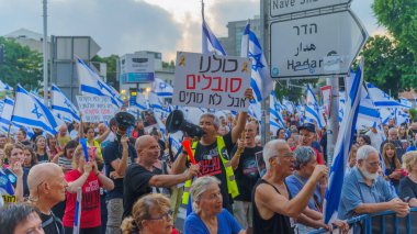 Hayfa, İsrail - 20 Temmuz 2024: Çeşitli tabela ve bayraklı bir kalabalık hükümete karşı düzenlenen protesto mitingine katılarak yeni seçimler çağrısında bulundu. Hayfa, İsrail