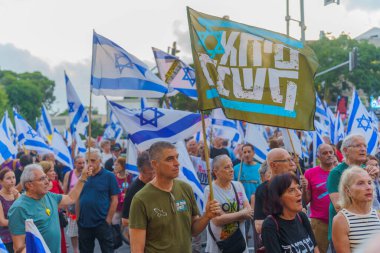 Hayfa, İsrail - 20 Temmuz 2024: Çeşitli tabela ve bayraklı bir kalabalık hükümete karşı düzenlenen protesto mitingine katılarak yeni seçimler çağrısında bulundu. Hayfa, İsrail