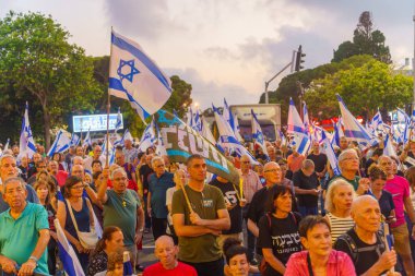 Hayfa, İsrail - 20 Temmuz 2024: Çeşitli tabela ve bayraklı bir kalabalık hükümete karşı düzenlenen protesto mitingine katılarak yeni seçimler çağrısında bulundu. Hayfa, İsrail
