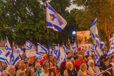 Hayfa, İsrail - 20 Temmuz 2024: Çeşitli tabela ve bayraklı bir kalabalık hükümete karşı düzenlenen protesto mitingine katılarak yeni seçimler çağrısında bulundu. Hayfa, İsrail