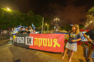 Hayfa, İsrail - 24 Temmuz 2024: Çeşitli tabelaları ve bayrakları olan insanlar, Başbakan 'ın kongreye hitaben yaptığı konuşmadan önce rehine anlaşması çağrısında bulunarak hükümete karşı düzenlenen bir protestoya katıldılar. Hayfa, İsrail