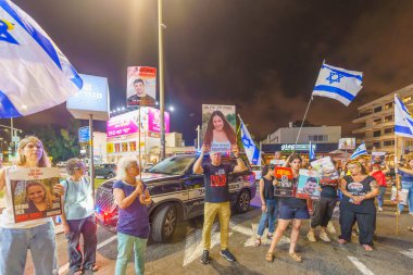 Hayfa, İsrail - 24 Temmuz 2024: Çeşitli tabelaları ve bayrakları olan insanlar, Başbakan 'ın kongreye hitaben yaptığı konuşmadan önce rehine anlaşması çağrısında bulunarak hükümete karşı düzenlenen bir protestoya katıldılar. Hayfa, İsrail