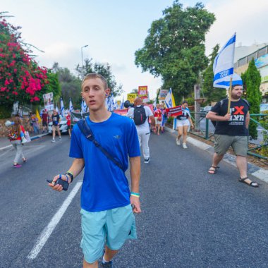 Hayfa, İsrail - 27 Temmuz 2024: Hükümete karşı bir protesto yürüyüşü sahnesi, insanların katıldığı, çeşitli tabelalar ve bayraklarla yeni seçimler çağrısında bulundu. Hayfa, İsrail