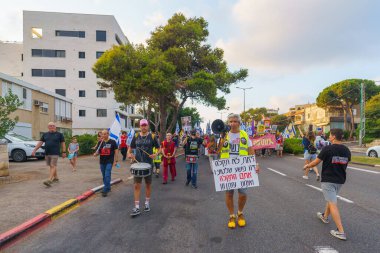 Hayfa, İsrail - 27 Temmuz 2024: Hükümete karşı bir protesto yürüyüşü sahnesi, insanların katıldığı, çeşitli tabelalar ve bayraklarla yeni seçimler çağrısında bulundu. Hayfa, İsrail