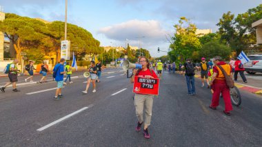 Hayfa, İsrail - 27 Temmuz 2024: Hükümete karşı bir protesto yürüyüşü sahnesi, insanların katıldığı, çeşitli tabelalar ve bayraklarla yeni seçimler çağrısında bulundu. Hayfa, İsrail