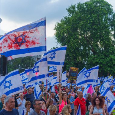 Hayfa, İsrail - 27 Temmuz 2024: Çeşitli tabela ve bayraklı bir kalabalık hükümete karşı düzenlenen protesto mitingine katılarak yeni seçimler çağrısında bulundu. Hayfa, İsrail