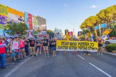 Hayfa, İsrail - 3 Ağustos 2024: Hükümete karşı bir protesto yürüyüşü sahnesi, insanların katıldığı, çeşitli tabelalar ve bayraklarla yeni seçimler çağrısında bulundu. Hayfa, İsrail