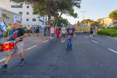 Hayfa, İsrail - 3 Ağustos 2024: Hükümete karşı bir protesto yürüyüşü sahnesi, insanların katıldığı, çeşitli tabelalar ve bayraklarla yeni seçimler çağrısında bulundu. Hayfa, İsrail