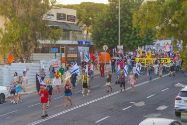 Hayfa, İsrail - 3 Ağustos 2024: Hükümete karşı bir protesto yürüyüşü sahnesi, insanların katıldığı, çeşitli tabelalar ve bayraklarla yeni seçimler çağrısında bulundu. Hayfa, İsrail