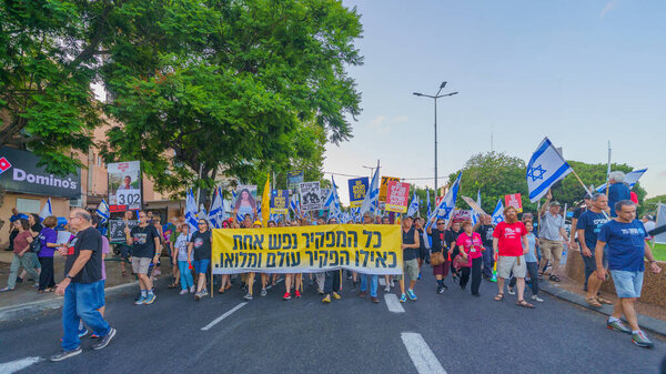 Haifa, Israel - August 03, 2024: Scene of a protest march, against the government, calling for new elections, with people taking part, various signs and flags. Haifa, Israel