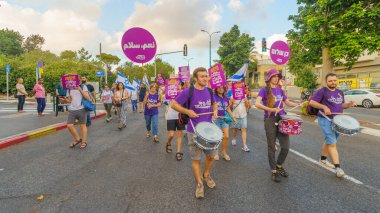 Hayfa, İsrail - 10 Ağustos 2024: İnsanlar hükümete karşı çeşitli tabela ve bayraklarla birlikte yeni seçimler çağrısında bulunan bir protesto yürüyüşüne katılıyor. Hayfa, İsrail