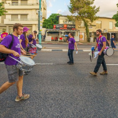 Hayfa, İsrail - 10 Ağustos 2024: İnsanlar hükümete karşı çeşitli tabela ve bayraklarla birlikte yeni seçimler çağrısında bulunan bir protesto yürüyüşüne katılıyor. Hayfa, İsrail