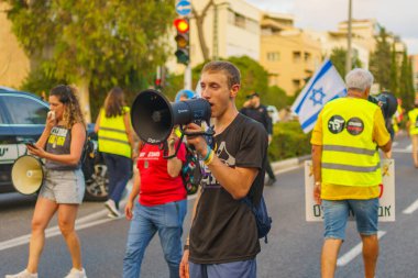 Hayfa, İsrail - 10 Ağustos 2024: Bir protesto yürüyüşü sahnesi, hükümete karşı, insanların katıldığı, çeşitli tabelalar ve bayraklarla yeni seçimler çağrısında bulundu. Hayfa, İsrail