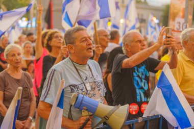 Hayfa, İsrail - 10 Ağustos 2024: Çeşitli tabela ve bayraklı bir kalabalık hükümete karşı düzenlenen protesto mitingine katılarak yeni seçimler çağrısında bulundu. Hayfa, İsrail