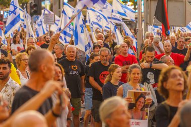 Hayfa, İsrail - 10 Ağustos 2024: Çeşitli tabela ve bayraklı bir kalabalık hükümete karşı düzenlenen protesto mitingine katılarak yeni seçimler çağrısında bulundu. Hayfa, İsrail