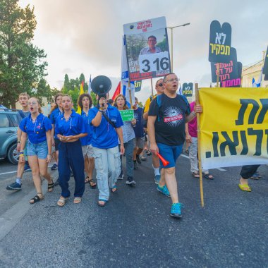 Hayfa, İsrail - 17 Ağustos 2024: İnsanlar hükümete karşı çeşitli tabela ve bayraklarla yeni seçimler çağrısında bulunan bir protesto yürüyüşüne (Hashomer Hatzair gençlik hareketi) katılıyor. Hayfa, İsrail