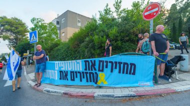 Hayfa, İsrail - 17 Ağustos 2024: Çeşitli tabela ve bayraklara sahip insanlar hükümeti protesto ederek yeni seçim çağrısında bulundular. Hayfa, İsrail