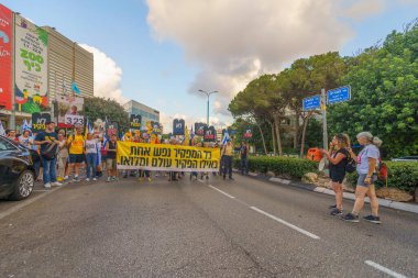 Hayfa, İsrail - 24 Ağustos 2024: Hükümete karşı bir protesto yürüyüşü sahnesi, insanların katıldığı, çeşitli tabelalar ve bayraklarla yeni seçimler çağrısında bulundu. Hayfa, İsrail