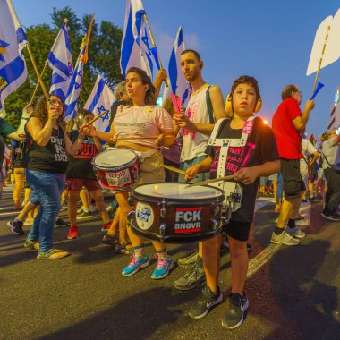 Hayfa, İsrail - 24 Ağustos 2024: İnsanlar, hükümete karşı çeşitli işaret ve bayraklarla yeni seçimler çağrısında bulunan bir protesto yürüyüşüne (pembe grup) katılıyor. Hayfa, İsrail