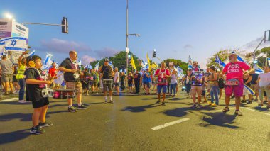 Hayfa, İsrail - 24 Ağustos 2024: İnsanlar, hükümete karşı çeşitli işaret ve bayraklarla yeni seçimler çağrısında bulunan bir protesto yürüyüşüne (pembe grup) katılıyor. Hayfa, İsrail