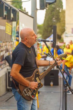 Hayfa, İsrail - 29 Ağustos 2024: Şarkıcı Amir Lev, İsrail 'in Hayfa kentindeki rehine ailelerine destek için kalabalığa şarkı söyledi