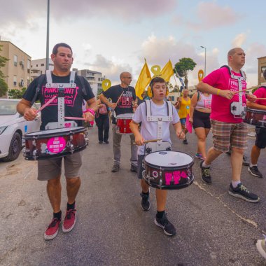 Hayfa, İsrail - 31 Ağustos 2024: İnsanlar hükümete karşı çeşitli tabela ve bayraklarla yeni seçimler çağrısında bulunan bir protesto yürüyüşüne (pembe grup) katılıyor. Hayfa, İsrail