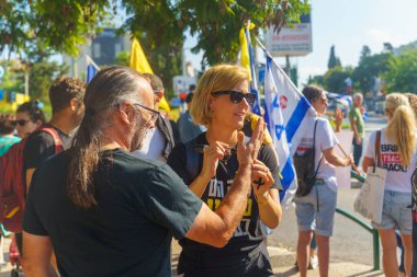 Hayfa, İsrail - 02 Eylül 2024: Avuçlarında rehine posterleri ve kurdele ikonu olan insanlar, protesto, rehine anlaşması için Hayfa, İsrail 'de çağrı
