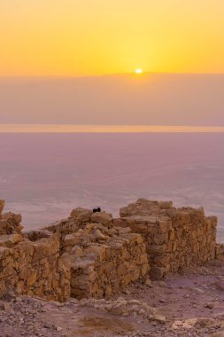 Masada Kalesi 'nin ve Ölü Deniz' in, İsrail 'in güneyindeki Judaean Çölü' nün kalıntılarının gündoğumu manzarası