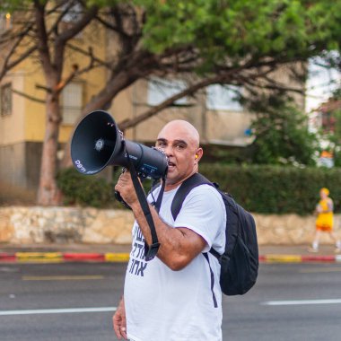 Hayfa, İsrail - 07 Eylül 2024: Hükümete karşı bir protesto yürüyüşü sahnesi, insanların katıldığı, çeşitli tabelalar ve bayraklarla yeni seçimler çağrısında bulundu. Hayfa, İsrail