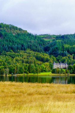 Lomond Gölü ve Trossachs Ulusal Parkı 'ndaki Tigh Mor Kalesi ve Loch Achray Gölü manzarası.