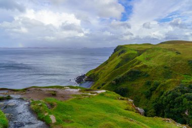 Lealt Şelalesi yakınlarında, Skye Adası, Inner Hebrides, İskoçya, İngiltere 'de kıyı manzarası ve gökkuşağı.