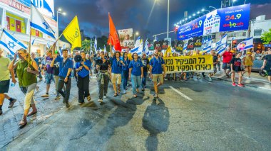 Hayfa, İsrail - 14 Eylül 2024: İnsanlar çeşitli işaret ve bayraklarla yeni seçimler çağrısında bulunan bir protesto yürüyüşüne (Hashomer Hatzair gençlik hareketi) katılıyor. Hayfa, İsrail