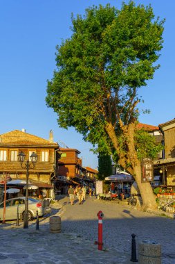 Nesebar, Bulgaristan - 20 Eylül 2023: Bulgaristan 'ın eski Nesebar kentinde dükkanlar, yerel halk ve ziyaretçilerin olduğu sokak sahnesi