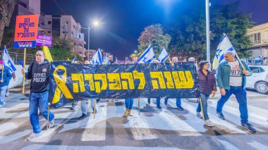 Hayfa, İsrail - 07 Aralık 2024: Hükümete karşı bir protesto yürüyüşü sahnesi, yeni seçimler ve insanların yer aldığı bir rehine anlaşması, çeşitli tabelalar ve bayraklar. Hayfa, İsrail