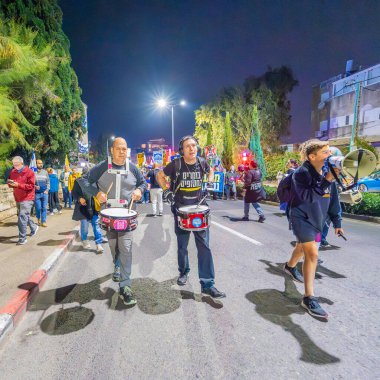 Hayfa, İsrail - 07 Aralık 2024: Hükümete karşı bir protesto yürüyüşü sahnesi, yeni seçimler ve insanların yer aldığı bir rehine anlaşması, çeşitli tabelalar ve bayraklar. Hayfa, İsrail