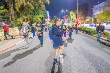 Hayfa, İsrail - 07 Aralık 2024: Hükümete karşı bir protesto yürüyüşü sahnesi, yeni seçimler ve insanların yer aldığı bir rehine anlaşması, çeşitli tabelalar ve bayraklar. Hayfa, İsrail