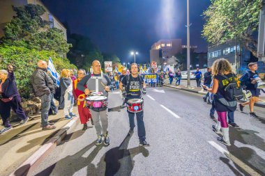 Hayfa, İsrail - 07 Aralık 2024: Hükümete karşı bir protesto yürüyüşü sahnesi, yeni seçimler ve insanların yer aldığı bir rehine anlaşması, çeşitli tabelalar ve bayraklar. Hayfa, İsrail