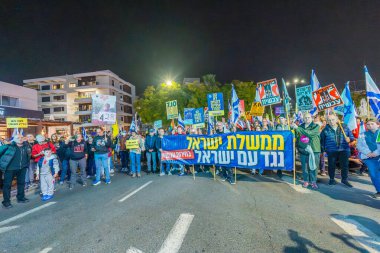 Hayfa, İsrail - 07 Aralık 2024: Hükümete karşı bir protesto yürüyüşü sahnesi, yeni seçimler ve insanların yer aldığı bir rehine anlaşması, çeşitli tabelalar ve bayraklar. Hayfa, İsrail