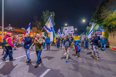 Hayfa, İsrail - 07 Aralık 2024: Hükümete karşı bir protesto yürüyüşü sahnesi, yeni seçimler ve insanların yer aldığı bir rehine anlaşması, çeşitli tabelalar ve bayraklar. Hayfa, İsrail