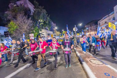 Hayfa, İsrail - 07 Aralık 2024: Hükümete karşı bir protesto yürüyüşü sahnesi, yeni seçimler ve insanların yer aldığı bir rehine anlaşması, çeşitli tabelalar ve bayraklar. Hayfa, İsrail
