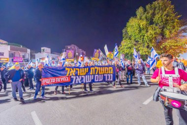 Hayfa, İsrail - 07 Aralık 2024: Hükümete karşı bir protesto yürüyüşü sahnesi, yeni seçimler ve insanların yer aldığı bir rehine anlaşması, çeşitli tabelalar ve bayraklar. Hayfa, İsrail