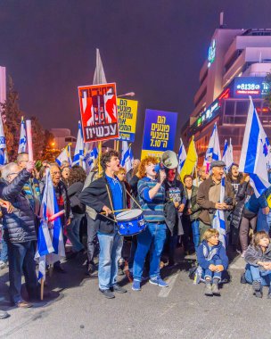 Hayfa, İsrail - 07 Aralık 2024: Çeşitli tabela ve bayraklara sahip bir kalabalık yeni seçimler ve bir rehine anlaşması çağrısında bulundu. Hayfa, İsrail